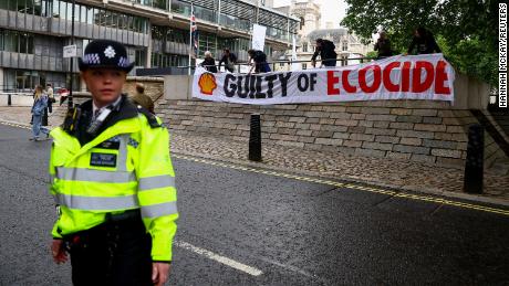 A police officer pictured in front of a banner outside Shell headquarters in London.