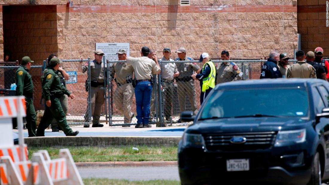 Law enforcement officials and other first responders gather outside the school following the shooting. 