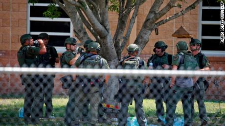 Law enforcement personnel stand outside Robb Elementary School following the shooting.