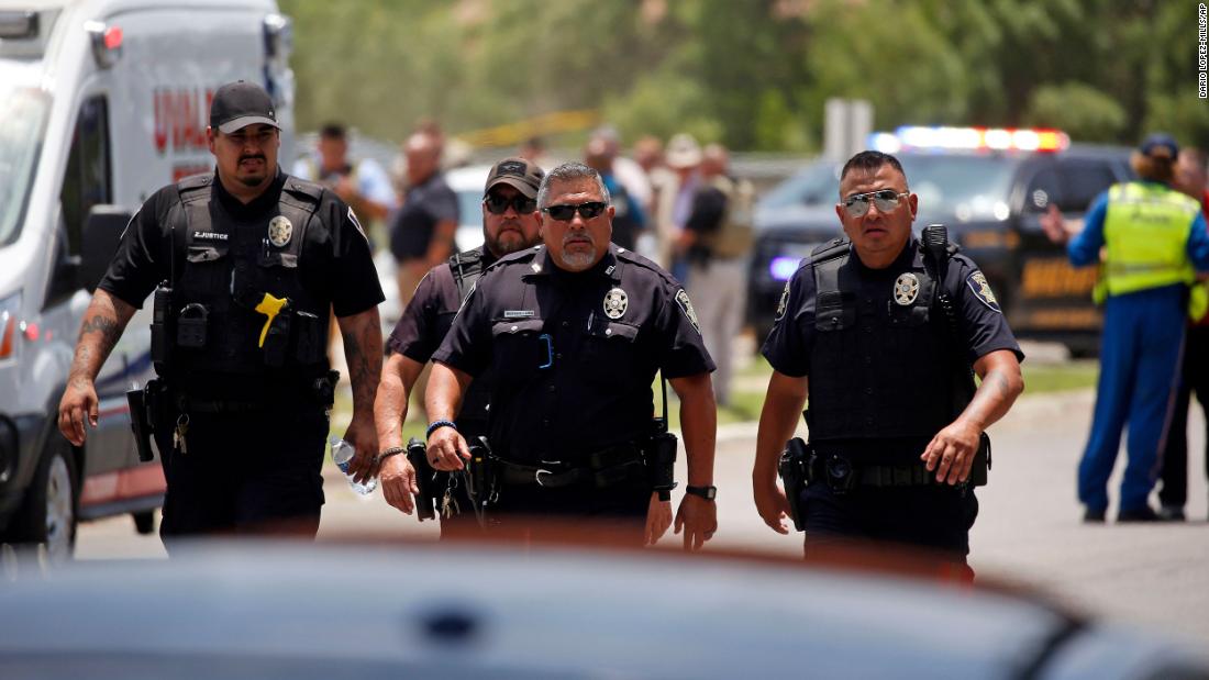 Police walk near the school following the shooting.