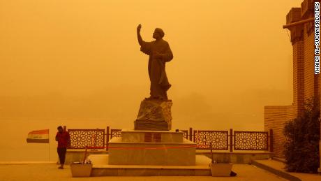 A man stands near a statue of the famous Arab poet al-Mutanabbi during a sandstorm in Baghdad, Iraq, on May 23.