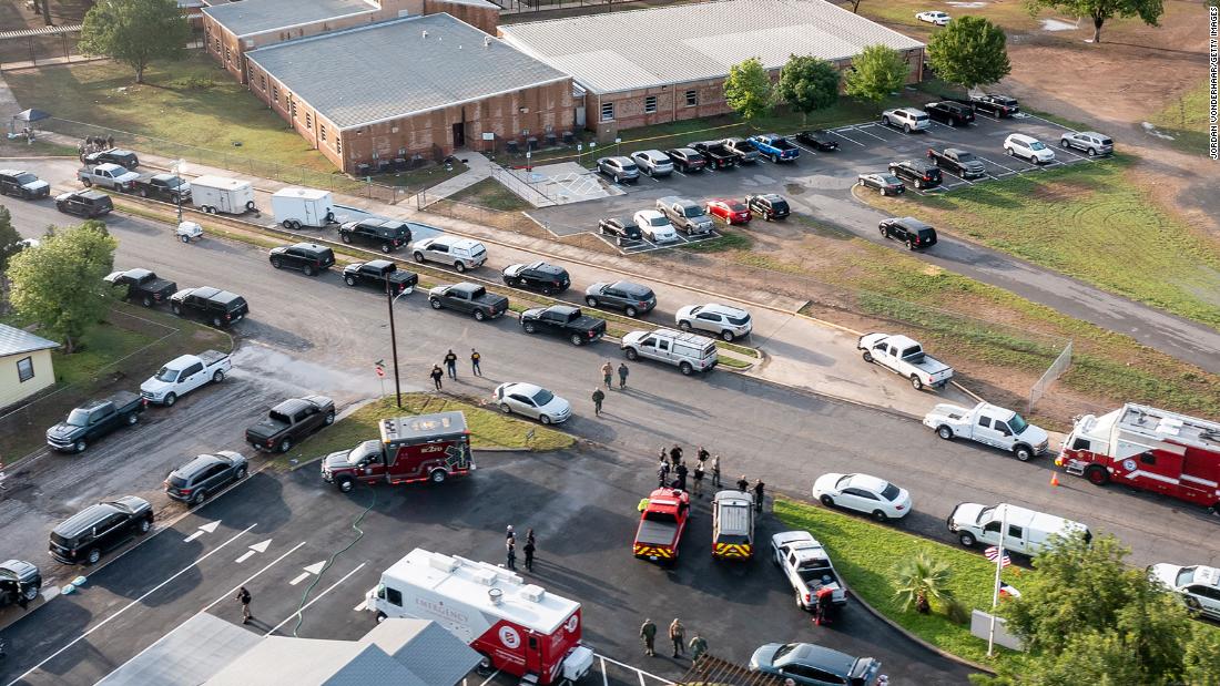 Law enforcement vehicles are lined up outside the school on May 25.