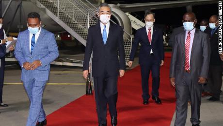 Solomon Islands Foreign Minister Jeremiah Manele (L) and Chief Protocole Walter Diamana (R) escort Chinese Foreign Minister Wang Yi (C) upon his arrival in Honiara on May 25, 2022.