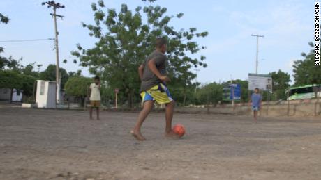 Niños descalzos juegan fútbol en el campo de arena frente a la casa de la familia Díaz en Barrancas a principios de este mes.