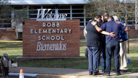 People gather at Robb Elementary School, the scene of a mass shooting in Uvalde, Texas, U.S. May 25, 2022.  REUTERS/Nuri Vallbona