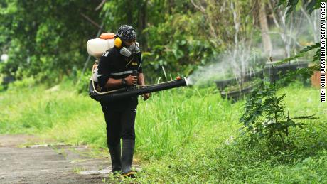 Een werknemer spuit insecticide om dengue te bestrijden in Singapore, 6 juli 2021.