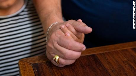 週四，66 歲的胡安·馬丁內斯（右）與他的侄女 7 歲的吉莉安·馬丁內斯（左）在馬丁內斯的聯排別墅餐廳握手。