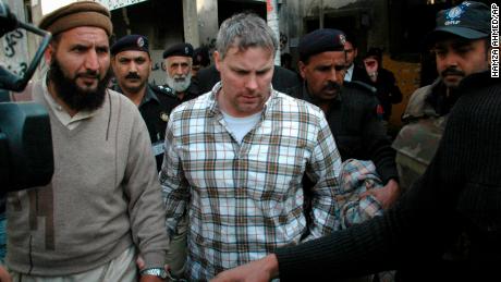 पाकिस्तानी सुरक्षा अधिकारी 28 जनवरी, 2011 को रेमंड डेविस, केंद्र को लाहौर की एक अदालत में ले जाते हैं।