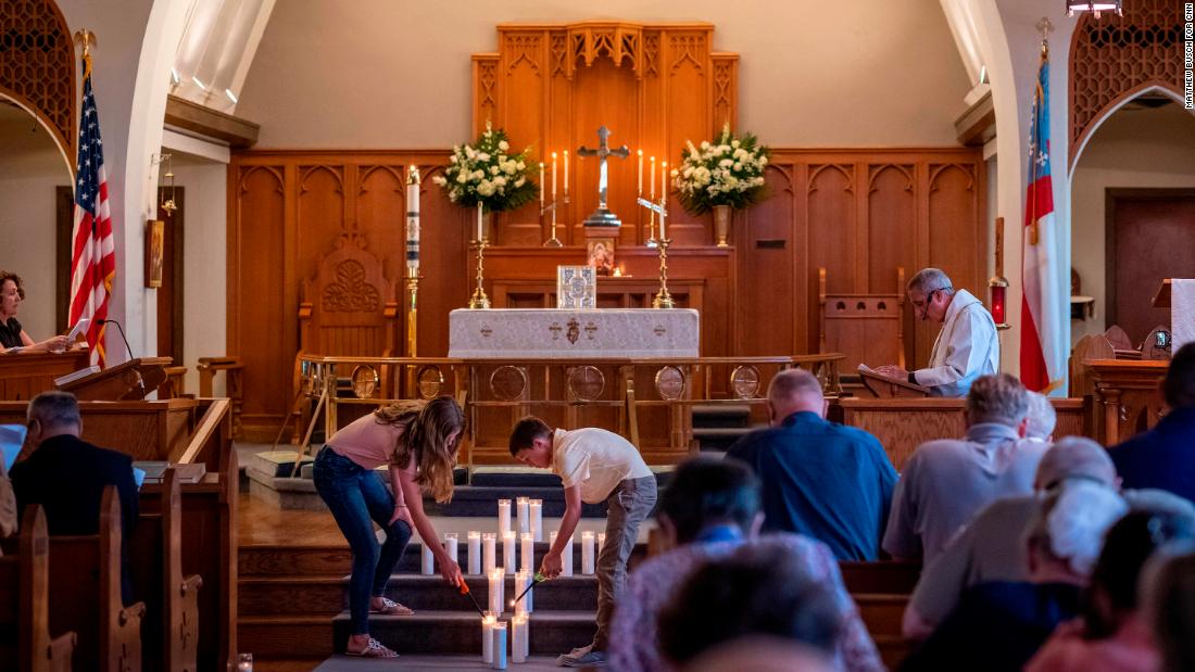 Congregants at St Philip&#39;s Episcopal Church light candles to remember the shooting victims on Thursday.