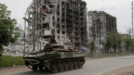 Service members of pro-Russian troops drive an armoured vehicle along a street past a destroyed residential building during Ukraine-Russia conflict in the town of Popasna in the Luhansk Region, Ukraine May 26, 2022. The writing on the vehicle reads: &quot;Valkyrie&quot;. REUTERS/Alexander Ermochenko