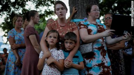 A woman embraces her children as she takes part in a ceremony in memory of the victims on Saturday.