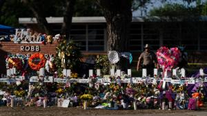 Flowers and candles are placed around crosses at a memorial outside Robb Elementary School to honor the victims killed in this week&#39;s school shooting in Uvalde, Texas, Saturday, May 28, 2022.