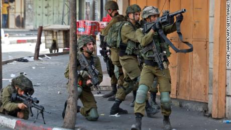 Israeli army soldiers take aim during clashes with protesters following a demonstration to denounce the 