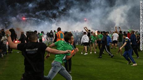 Saint-Étienne fans invade the pitch after being defeated at the end of the French relegation playoff second leg between AS St Étienne and AJ Auxerre at the Geoffroy Guichard Stadium.