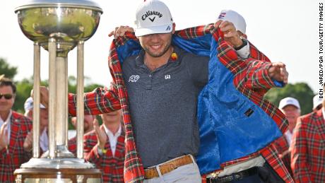 Sam Burns puts on the victor&#39;s tartan jacket during the trophy ceremony of the Charles Schwab Challenge.