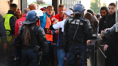 Police and stewards watch as Liverpool fans line up outside the stadium ahead of the UEFA Champions League final between Liverpool and Real Madrid at the Stade de France on May 28 in Paris. 