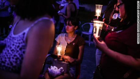A young woman holds a candle during a candlelight vigil to honor and remember the victims of the mass shooting in Uvalde, Texas on May 30, 2022.