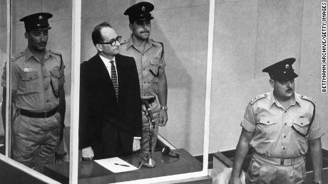 Ο Adolf Eichmann στέκεται στο αλεξίσφαιρο γυάλινο κλουβί του για να ακούσει το Ανώτατο Δικαστήριο του Ισραήλ να απορρίψει ομόφωνα μια έφεση κατά της θανατικής καταδίκης του στην Ιερουσαλήμ στις 29 Μαΐου 1962.  