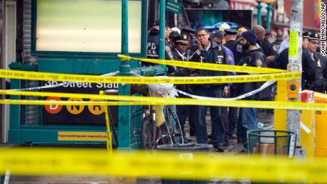 New York City Police Department personnel gather at the entrance to a subway stop in the Brooklyn borough of New York on April 12.