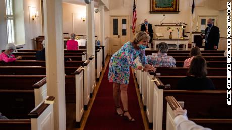 Tricia Melton razgovara s prijateljicom prije službe u crkvi Hopeful Baptist Church u nedjelju, 17. svibnja 2020., u Montpelieru u Virginiji.  Službenici javnog zdravstva ponekad su se sukobljavali s crkvenim vođama koji su održavali osobne službe u prvim mjesecima pandemije.