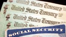 WASHINGTON, DC - OCTOBER 14: In this photo illustration, a Social Security card sits alongside checks from the U.S. Treasury on October 14, 2021 in Washington, DC. The Social Security Administration announced recipients will receive an annual cost of living adjustment of 5.9%, the largest increase since 1982. The larger increase is aimed at helping to offset rising inflation. 