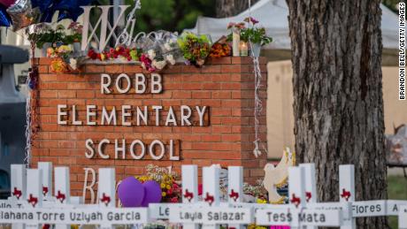  A memorial is seen surrounding the Robb Elementary School sign on May 26, 2022 in Uvalde, Texas. 