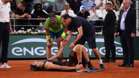 Alexander Zverev of Germany receives medical attention as Rafael Nadal of Spain looks on Friday in the men&#39;s semifinal match at the French Open.