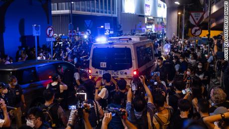 4 Haziran'da Hong Kong'daki Victoria Parkı yakınında bir protestocu taşıyan bir polis minibüsü.