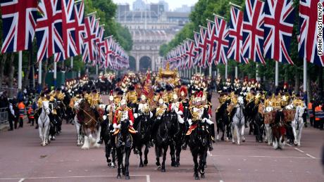 Players march outside Buckingham Palace in London during the Platinum Jubilee match on Sunday.