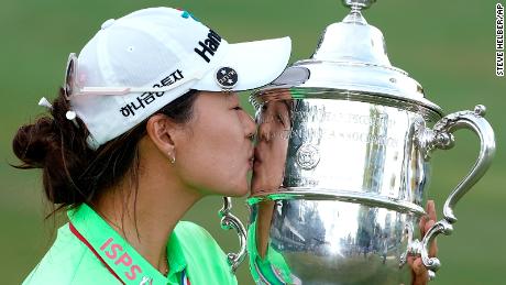 मिंजी ली ने यूएस महिला ओपन गोल्फ टूर्नामेंट के अंतिम दौर में जीत हासिल करने के बाद हार्टन एस. सेम्पल ट्रॉफी को चूमा।