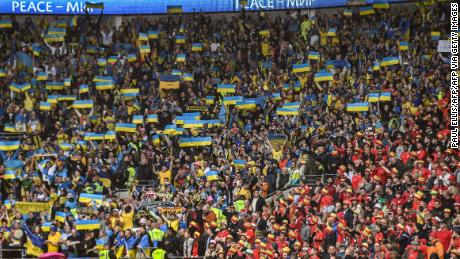 Украинские болельщики водружают флаг своей страны на стадионе Кардифф Сити. 
