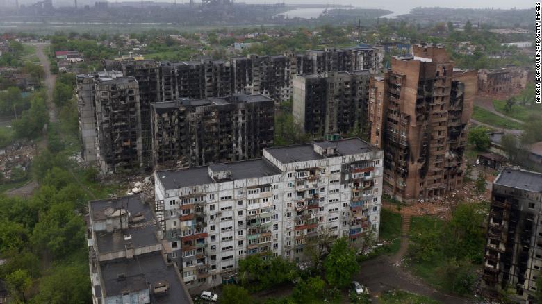 Damaged residential buildings in Mariupol, with the Azovstal steel plant in the background in May 2022. DPR authorities said the three men were captured in the port city by Russian forces in April.