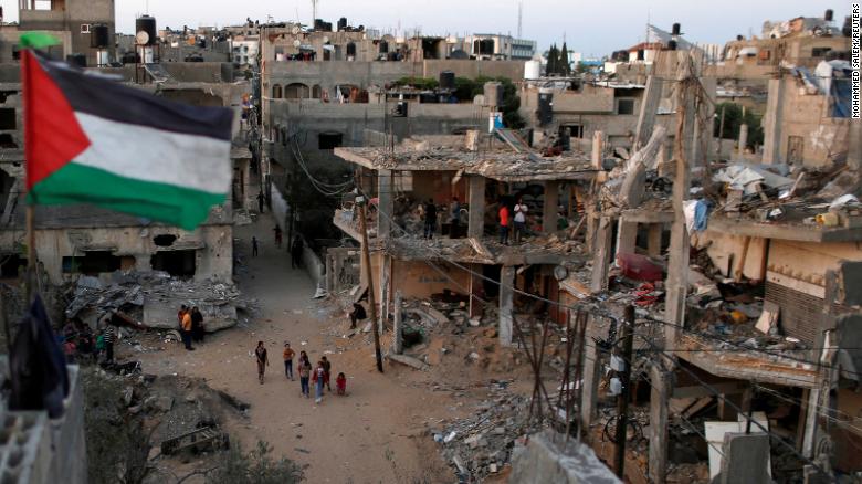 A Palestinian flag flies at the ruins of houses, destroyed by Israeli air strikes during Israeli-Palestinian fighting, in the Gaza Strip in May 2021.