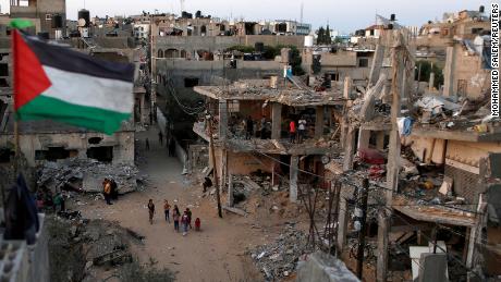 A Palestinian flag flies at the ruins of houses, destroyed by Israeli air strikes during Israeli-Palestinian fighting, in the Gaza Strip in May 2021.