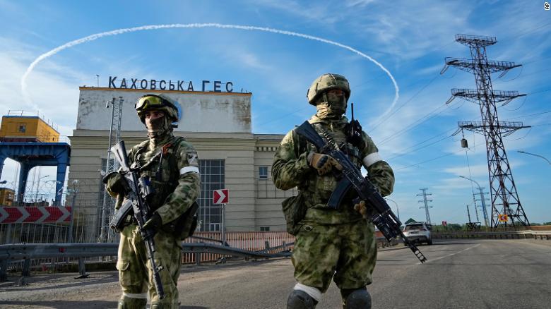 Russian troops guard an entrance of the Kakhovka power plant on the Dnieper River in southern Ukraine on May 20, 2022.