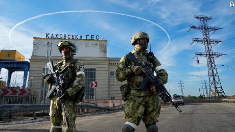 Russian troops guard an entrance to the Kakhovka power station on the Dnieper River in southern Ukraine on May 20, 2022.