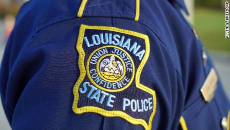 A Louisiana State Police trooper attends the funeral of a colleague in Baton Rouge, La., on Saturday, Oct. 16, 2021.