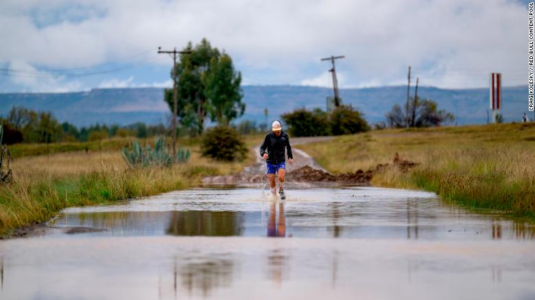 Sandes fording a river during the 16-day run around Lesotho. He says he went through a pair of socks every day.