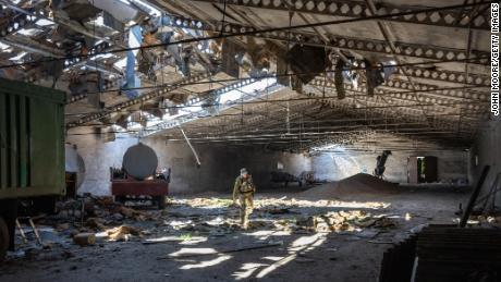 A Ukrainian army officer inspects a grain warehouse in Kherson region after it was shelled by Russian forces on May 6, 2022.