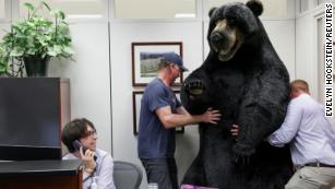 Jon Greene, defense advisor to Senator Jeanne Shaheen (D-NH), carries Kodak, the bear, to decorate the Senator&#39;s office on Capitol Hill to raise awareness about New Hampshire, while intern Roderck Emley takes calls, in Washington, U.S., June 7, 2022. REUTERS/Evelyn Hockstein TPX IMAGES OF THE DAY 