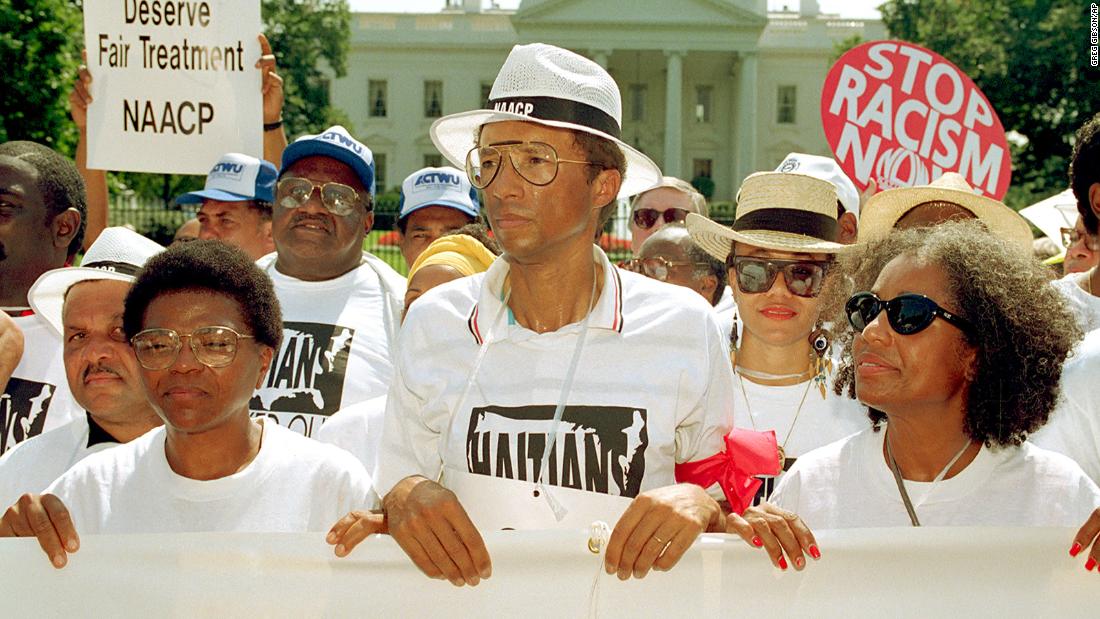 Ashe takes part in a demonstration outside the White House in 1992, protesting  the Bush administration's policy on Haitian refugees. He was later arrested during the protest.