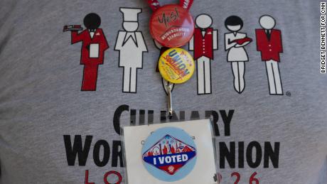 Carlos Padilla wears an &quot;I Voted&quot; sticker on his badge as he and other members from the Culinary Union canvass an apartment complex during Nevada&#39;s early voting period on June 1, 2022 in Las Vegas, Nevada.