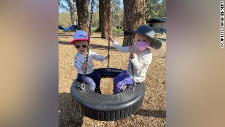 4-year-old Olivia (right) wears a mask while playing outside with her 20-month-old sister Abigail (left).