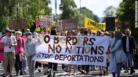 Demonstranti protestují před hraničním plotem letiště proti plánované deportaci žadatelů o azyl ze Spojeného království do Rwandy na letišti Gatwick 12. června 2022.