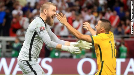 Australia&#39;s Andrew Redmayne and teammate Aziz Behich celebrate after qualifying for the FIFA World Cup on June 13.