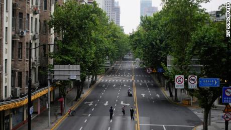 People stand on an empty street during lockdown in Shanghai, May 26, 2022. 