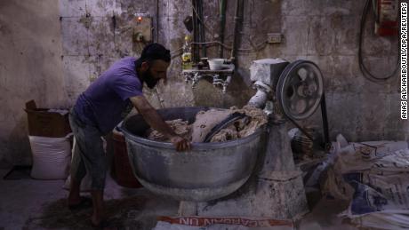 Seorang pekerja Suriah mengoperasikan mesin pengaduk adonan di sebuah toko roti di Kota Idlib pada 12 Juni. Pengawas telah memperingatkan potensi konsekuensi bencana jika pasokan gandum Suriah terganggu.  Negara yang dilanda perang itu sangat bergantung pada Rusia untuk sebagian besar pasokannya. 