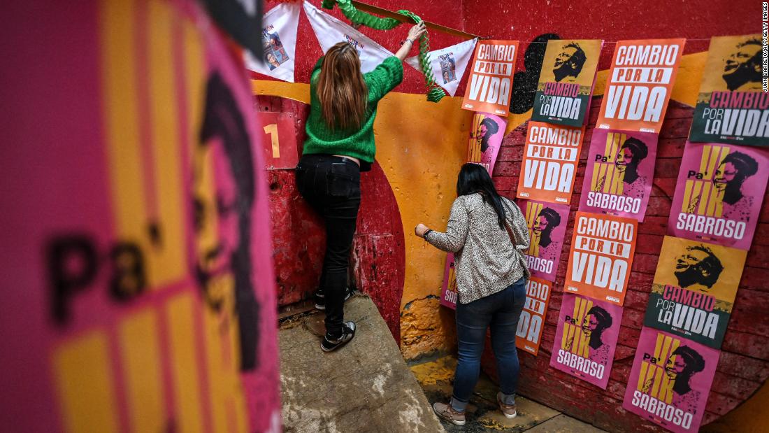 Supporters of Colombian left-wing presidential candidate Gustavo Petro paste banners before a rally at the Fontibon neighborhood in Bogota on June 12, 2022. 