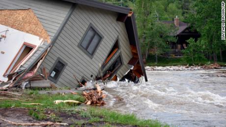 A house pulled into a flooded creek in Red Lodge, Montana, is photographed on Tuesday.