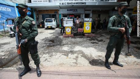 Soldiers stand guard at an empty fuel station in Colombo on June 15, 2022.